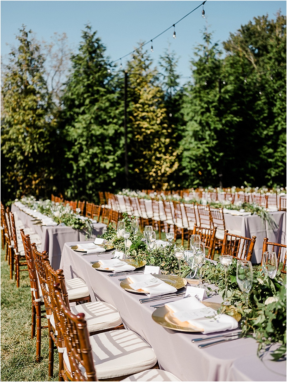 A playful Annapolis backyard wedding on the water featuring twinkle lights and greenery.